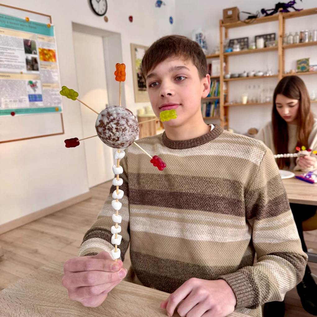 Учень середньої школи Домініон демонструє модель нейрона, виготовлену з солодощів на уроці біології