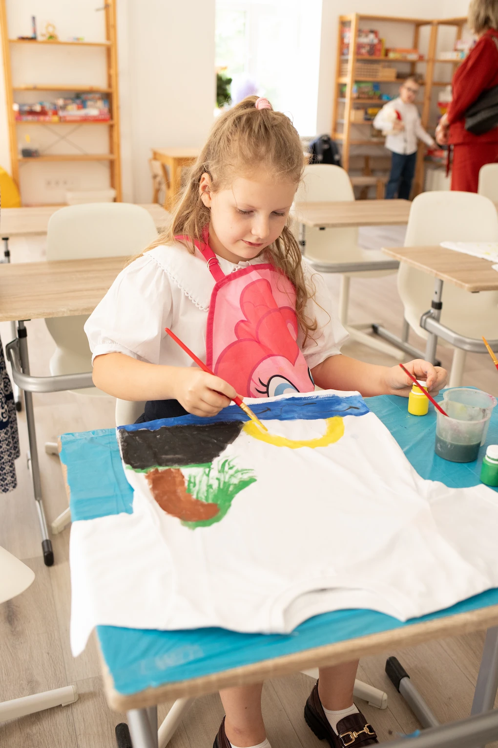 Учениця приватної школи Домініон розписує футболку на творчому майстер-класі